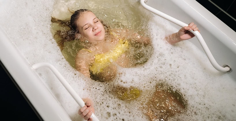 Child enjoying a relaxing bath in tub.